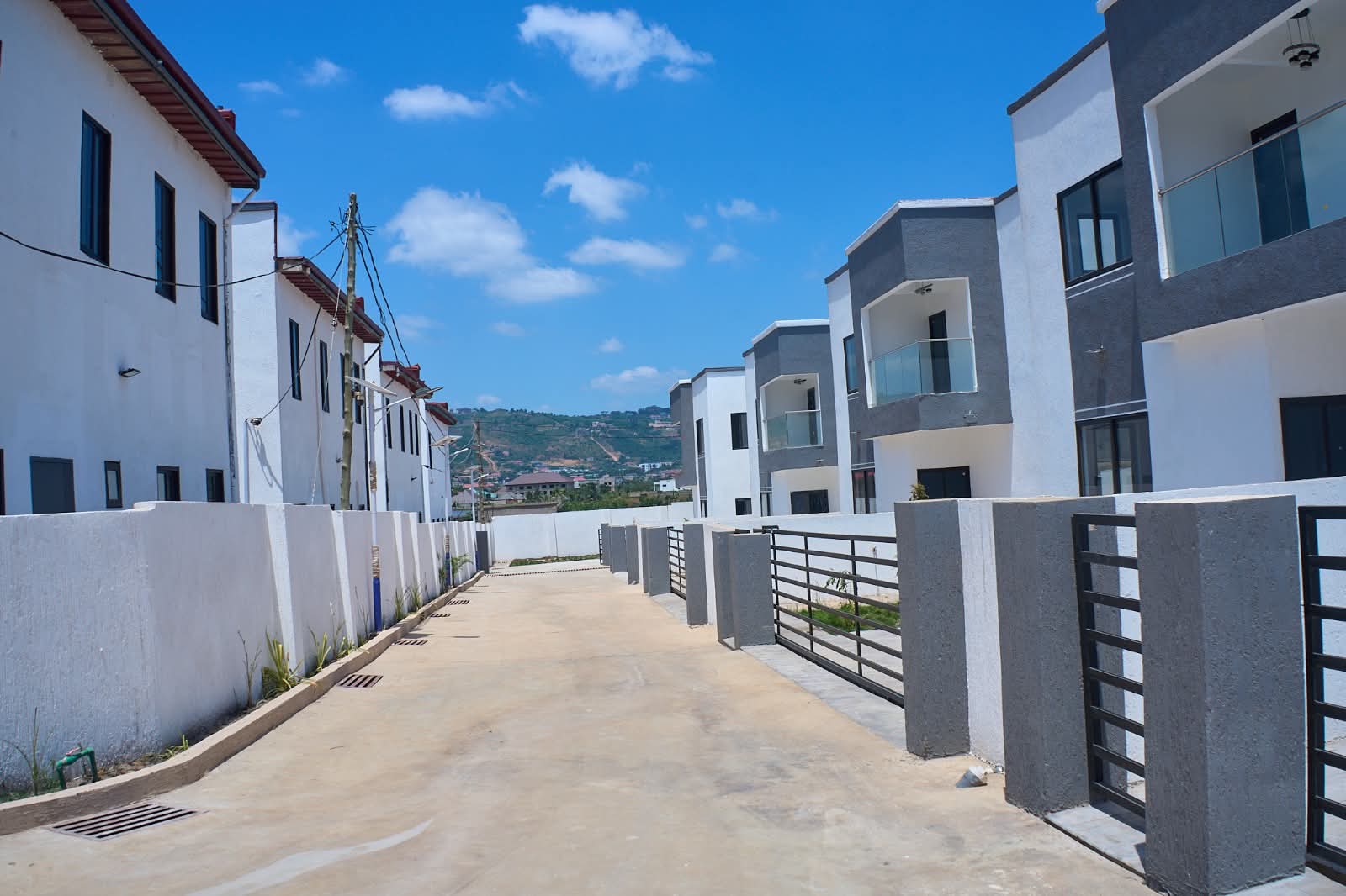 A paved lane between two rows of finished homes